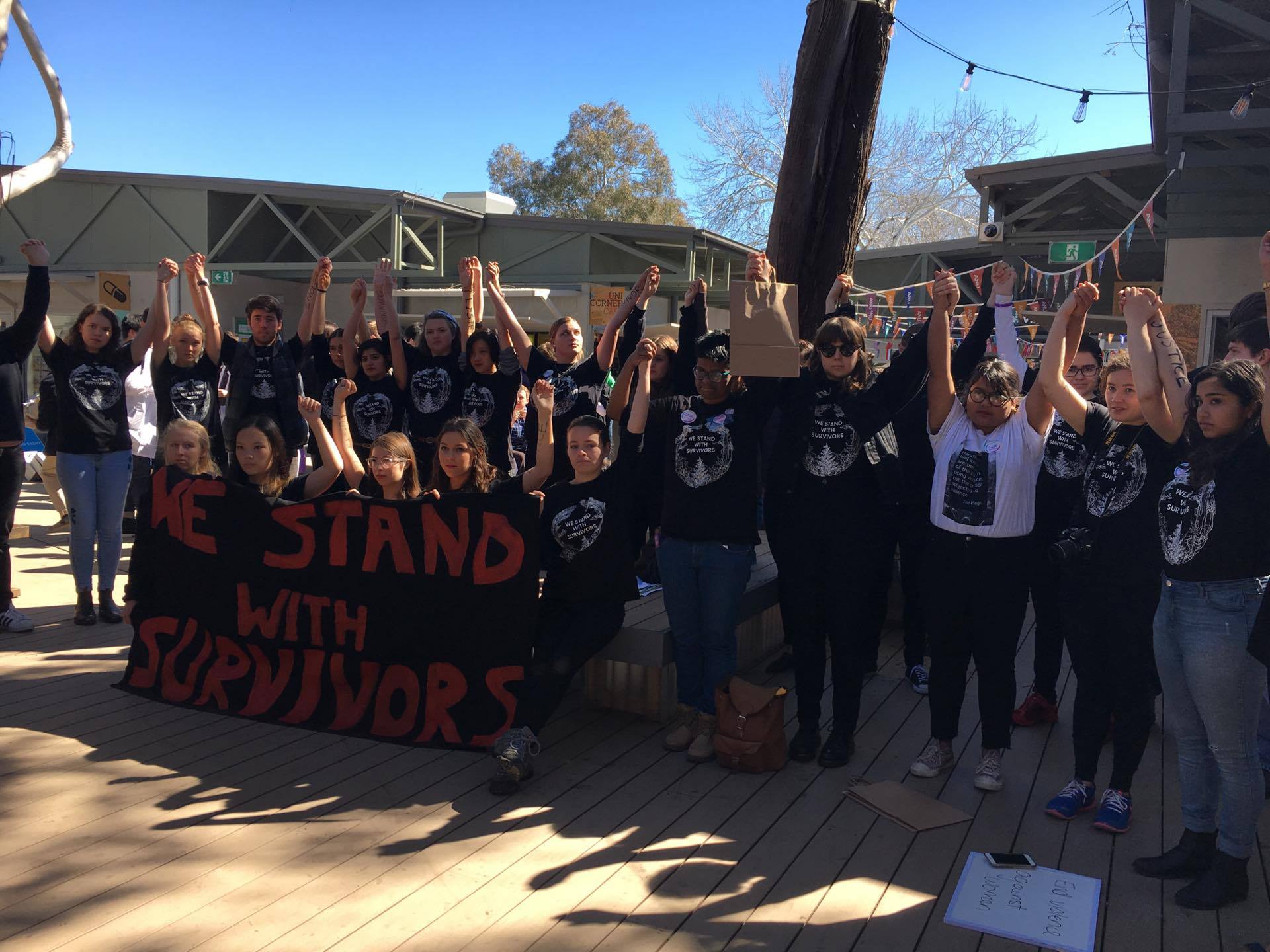 Students at the pop-up protesting, arms raised