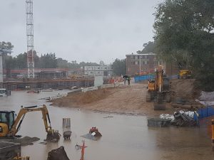 Two workers survey flooding in the Union Court Redevelopment.