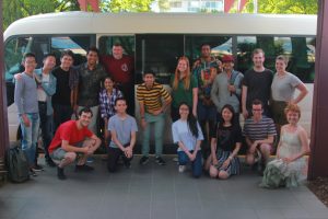 Students and drivers stand in front of shuttle bus